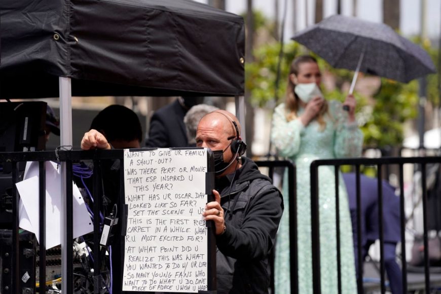 A video crew member holds up signage before the start of the Oscars on Sunday, April 25, 2021, at Union Station in Los Angeles
